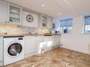 A kitchen with appliances and cabinets at Dairy Cottage in Bullhornstone near South Brent