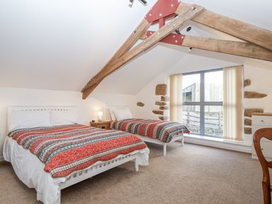 A bedroom with two beds and a window at Dairy Cottage Bullhornstone near South Brent