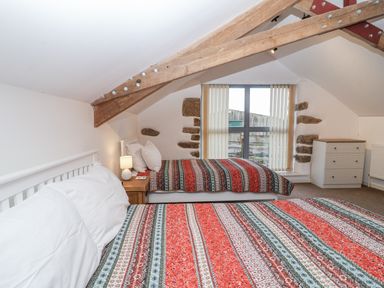 A bedroom with two beds and a window at Dairy Cottage Bullhornstone near South Brent