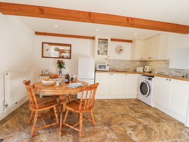 A kitchen with a table and chairs at Swallow Cottage Bullhornstone near South Brent
