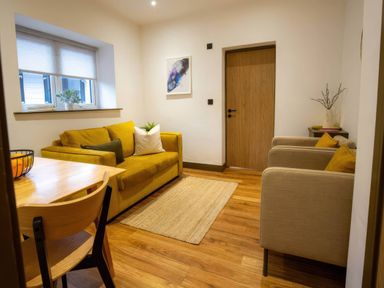 A living room with a sofa and armchairs at Aspen Apartment in Llanrwst
