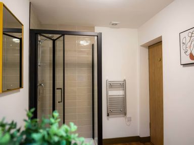 A bathroom with a shower and a towel rail at Aspen Apartment in Llanrwst