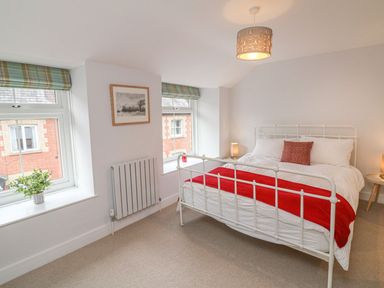 A bedroom with a bed and windows at The Old Workshop in 