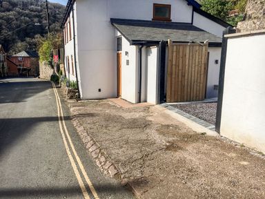 An outdoor view of a property with a wooden gate and gravel path at The Old Workshop in 