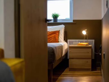A bedroom with a bed and bedside table at Oakwood Apartment in Llanrwst