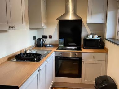 A kitchen with a sink and appliances at Ash Cottages Llanrwst