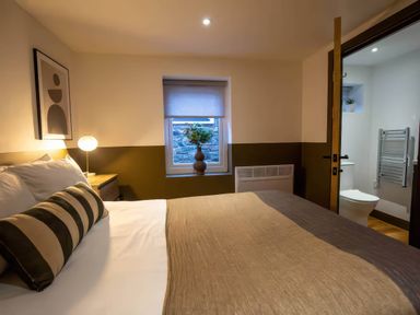A bedroom with a bed and window at Beech Cottages in Llanrwst