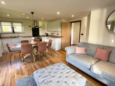 A living room with a sofa and dining table at River View Cottage in Llanrwst