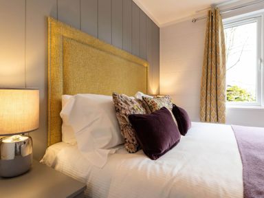 A bedroom with a bed and bedside lamp at The Falls in Leyburn
