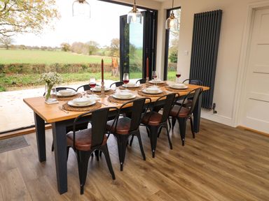 A dining room with a table set for dinner at Fairview in Darsham