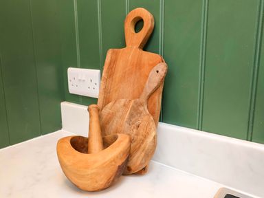 A mortar and pestle alongside wooden utensils in the kitchen at Fairview in Darsham