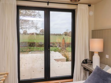 A bedroom with a sliding door leading to an outdoor area at Fairview in Darsham