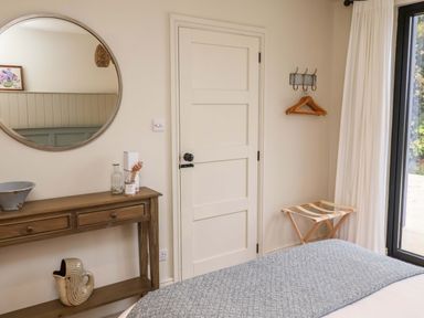 A bedroom with a bed and a mirror at Fairview in Darsham