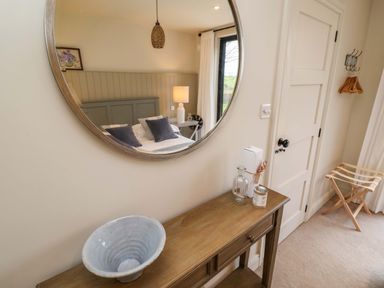 A mirror and wooden table in a bedroom at Fairview in Darsham