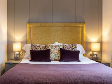 A bedroom with a bed and lamps on bedside tables at The Falls (Pet) Leyburn