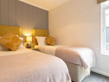 A bedroom with two beds and a window at The Falls (Pet) Leyburn