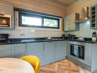 A kitchen with modern appliances including a microwave and oven at Middleham in Leyburn