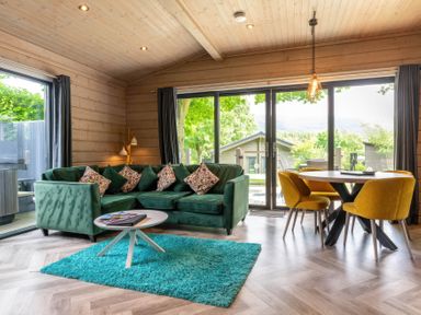 A living room with a green sofa and a dining area at Middleham (Pet) Leyburn