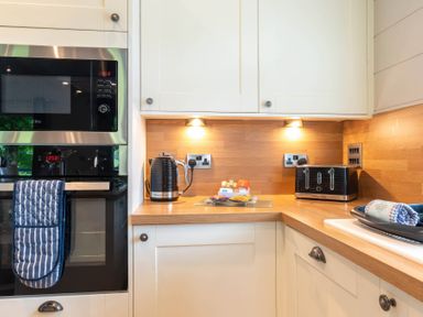 A kitchen with a microwave, oven, kettle, and toaster at Bainbridge in Leyburn