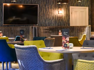 A dining room with a table and colorful chairs at Bainbridge Aysgarth