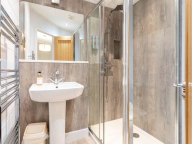 A bathroom with a sink, shower and heated towel rail at Bainbridge (Pet) Leyburn