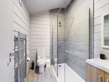 A bathroom with a shower, toilet, and washbasin at Leyburn