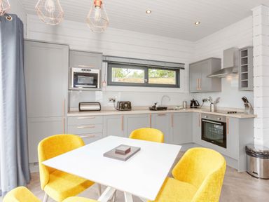 A kitchen with gray cabinets and yellow chairs at Leyburn (Pet) Leyburn