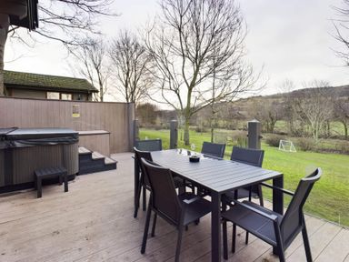 An outdoor dining area with a hot tub and table at Leyburn (Pet) Leyburn