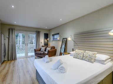 A bedroom with a bed and sofa at Tennyson Spa in Louth