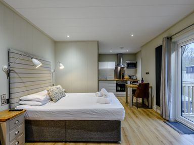 A studio apartment with a bed and kitchenette at Tennyson Spa in Louth