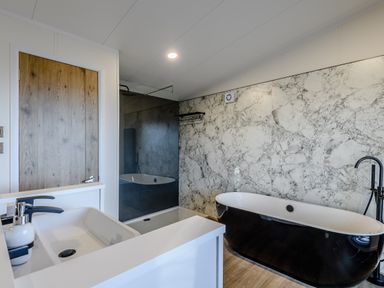 A bathroom with a bathtub and sink at Somersby Spa (Pet) in Louth