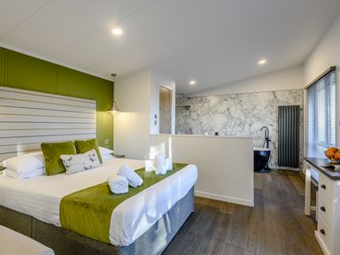 A bedroom with a bed and bath tub at Somersby Spa (Pet) in Louth