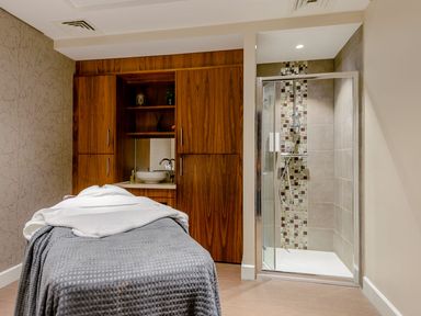 A spa room with a massage table and shower at Somersby Spa (Pet) in Louth