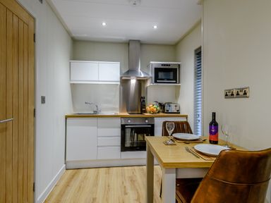 A kitchen with modern appliances and dining area at Tennyson Spa (Pet) in Louth