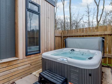 An outdoor area with a hot tub and a wooden fence at Tennyson Spa (Pet) Louth