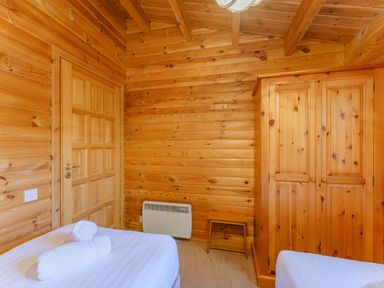 A bedroom with a wardrobe and towel at Maple Lodge in Louth