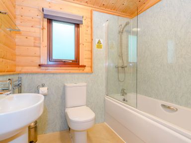 A bathroom with a sink, toilet, bathtub, and shower at Maple Lodge in Louth