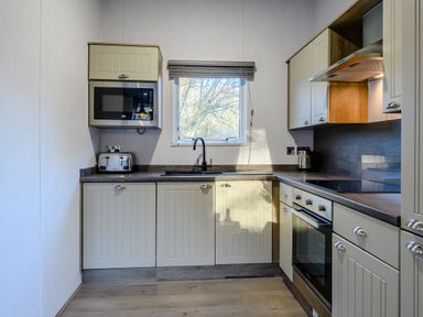 A kitchen with a sink, microwave, and oven at Horncastle Plus in Louth