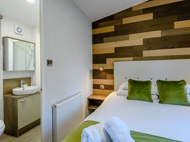 A bedroom with a bed and attached bathroom at Horncastle Plus in Louth