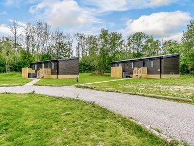 Two cabins with pathways in an outdoor area at Horncastle Spa Plus Louth