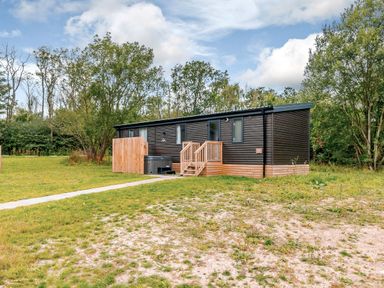 A mobile home with wooden deck and stairs at Horncastle Spa Plus in Louth