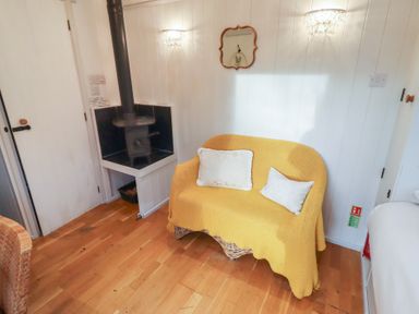 A snug with a sofa and wood stove at Meadows in Hexham