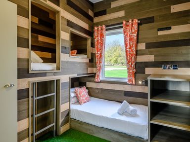 A bedroom with bunk beds and shelves at The Kinder Spa (Pet) in Louth