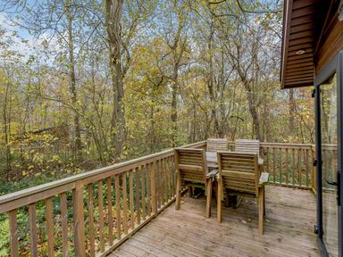 A deck with a table and chairs surrounded by trees at Alford Spa (Pet) Louth