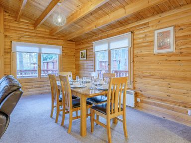 A dining room with a wooden table and chairs at Cedar Lodge in Louth