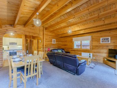 A living room with a dining table and sofa at Cedar Lodge in Louth