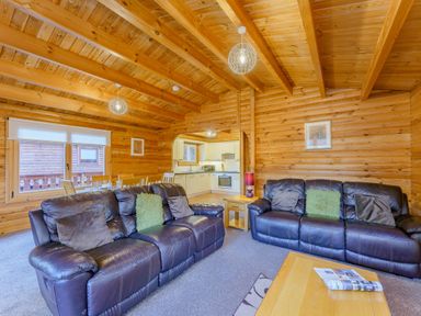 A living room with sofas and a dining table at Cedar Lodge in Louth