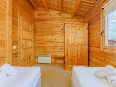 A bedroom with two beds and a wardrobe at Cedar Lodge in Louth