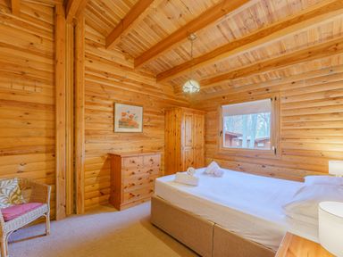 A bedroom with a bed and dresser at Cedar Lodge in Louth