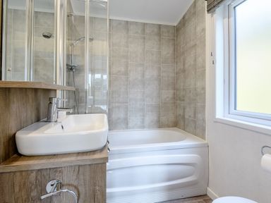 A bathroom with a bathtub, sink, and shower at Elsham Lodge in Louth